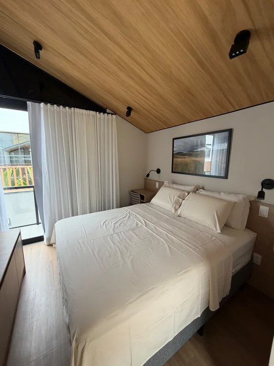 Quarto com enxoval e acabamento em madeira